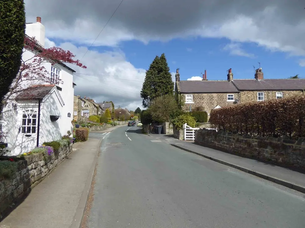 Main Street in Follifoot, with stone cottages and garden walls