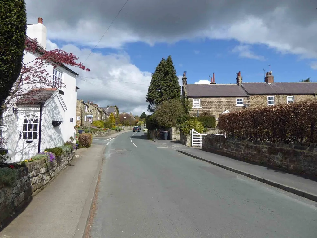 Main Street in Follifoot, with stone cottages and garden walls